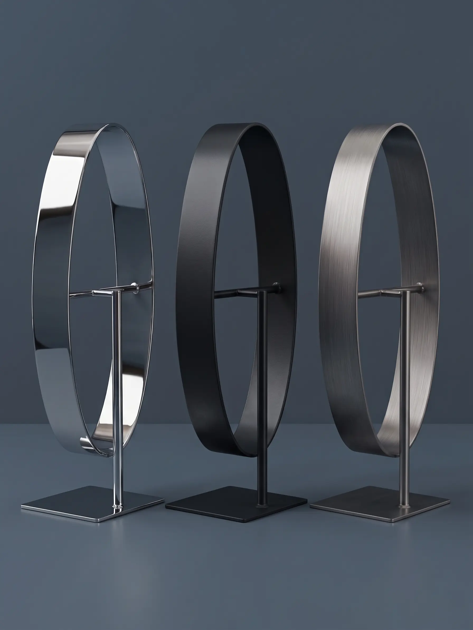 Three stainless steel shop displays with large circular rings, presented in polished, satin, and dark finishes