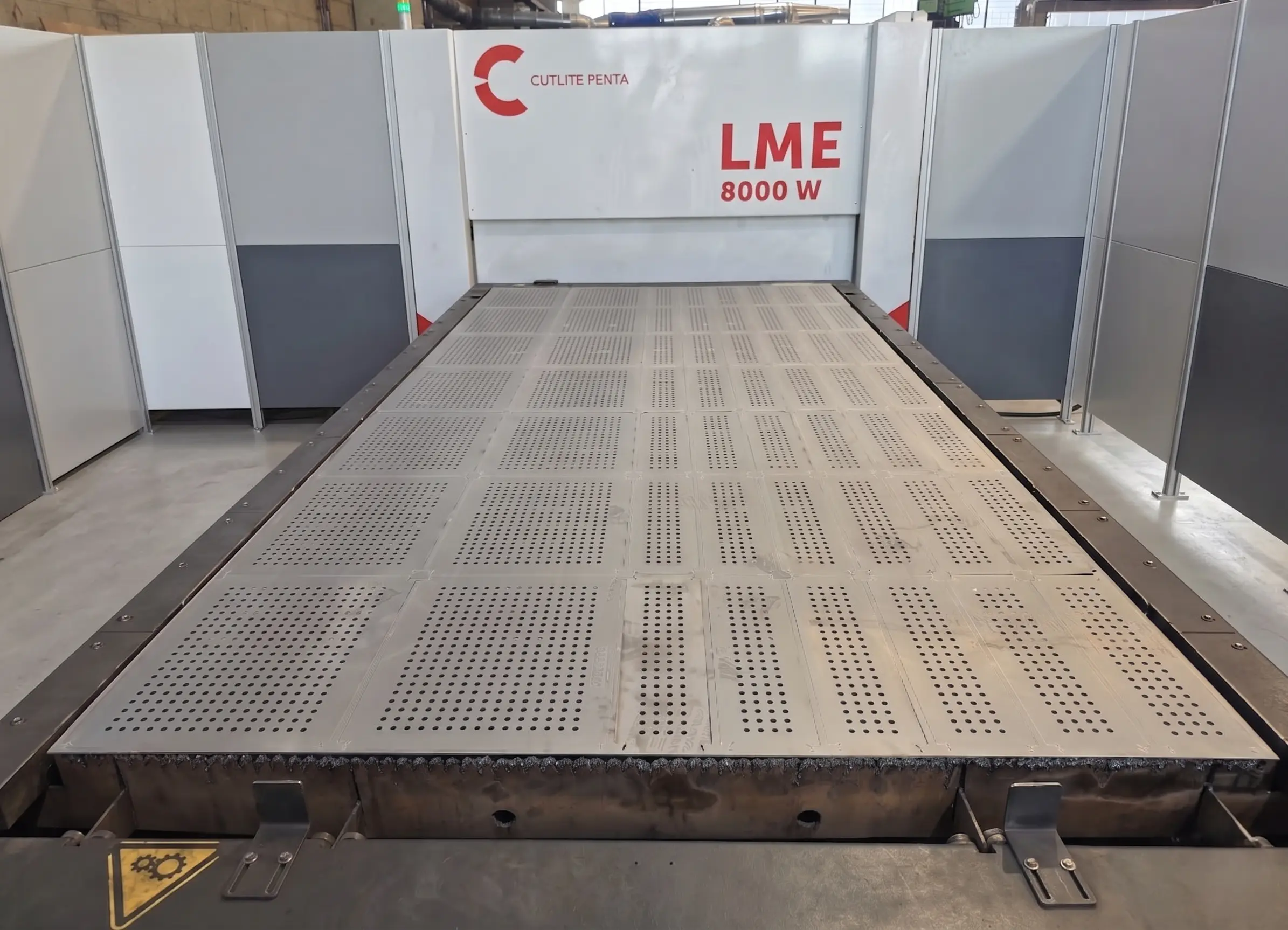 Large custom perforated sheet metal panel made via precision laser cutting, lifted by a hook
