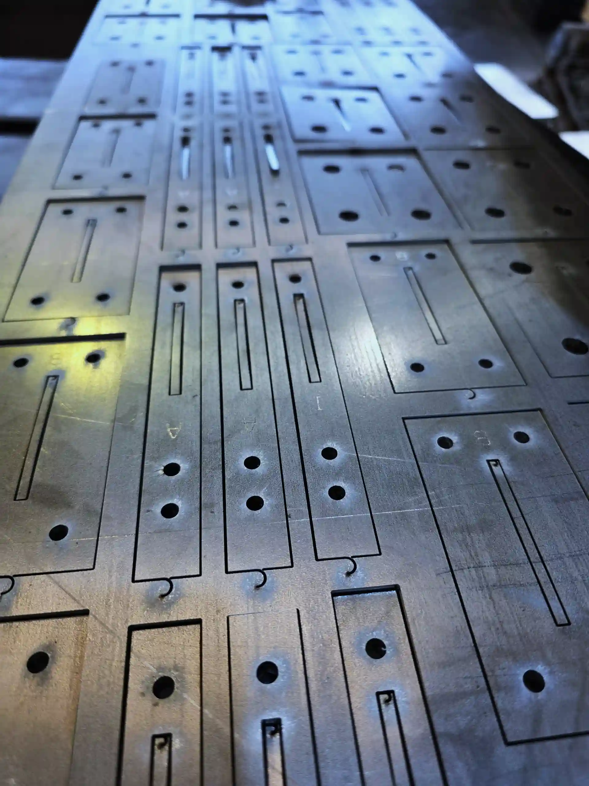 Flat sheet metal being processed with a series of regular rectangular holes