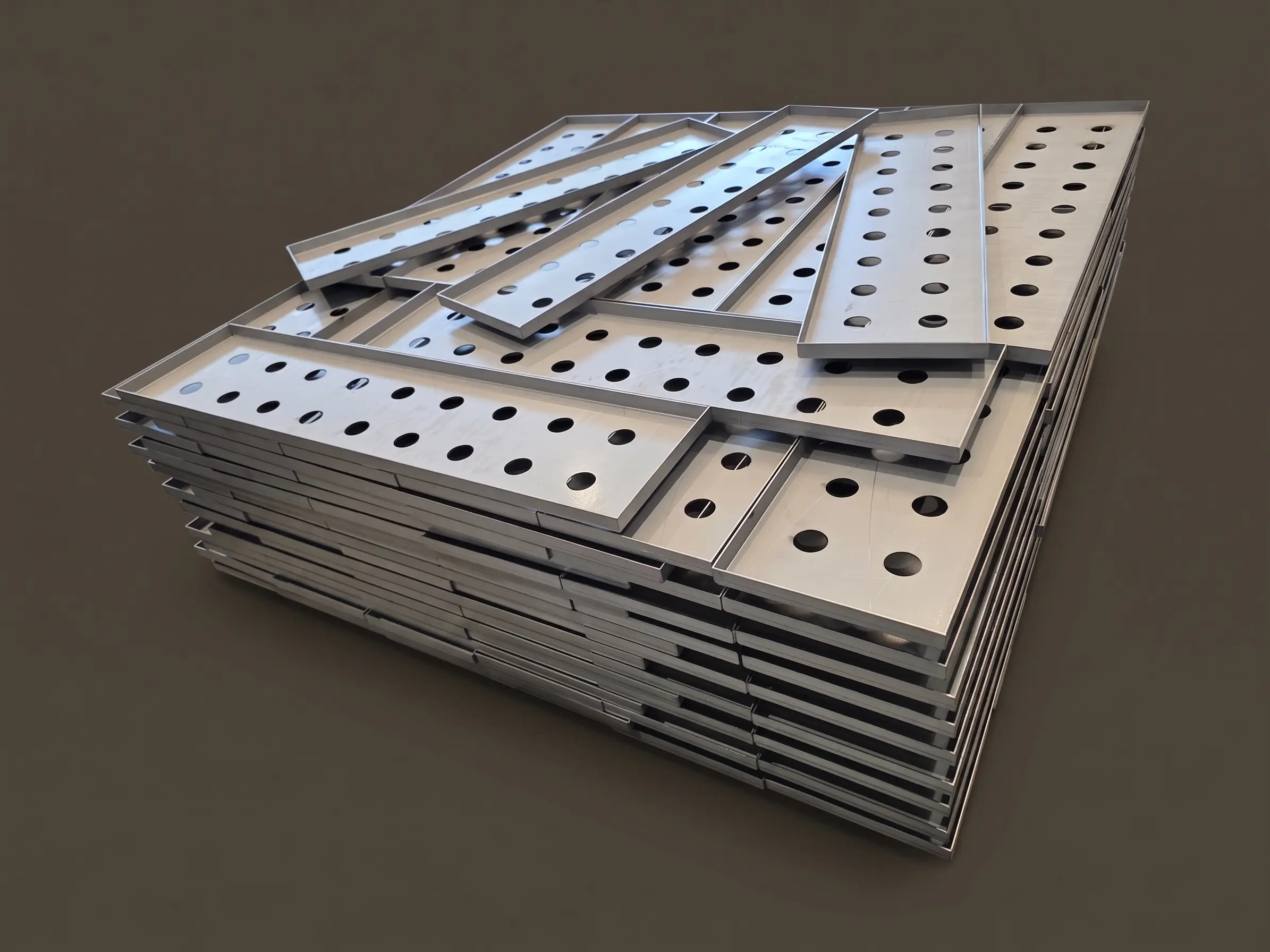 Long sheet metal profiles bent into C or U shapes, arranged in parallel on a pallet