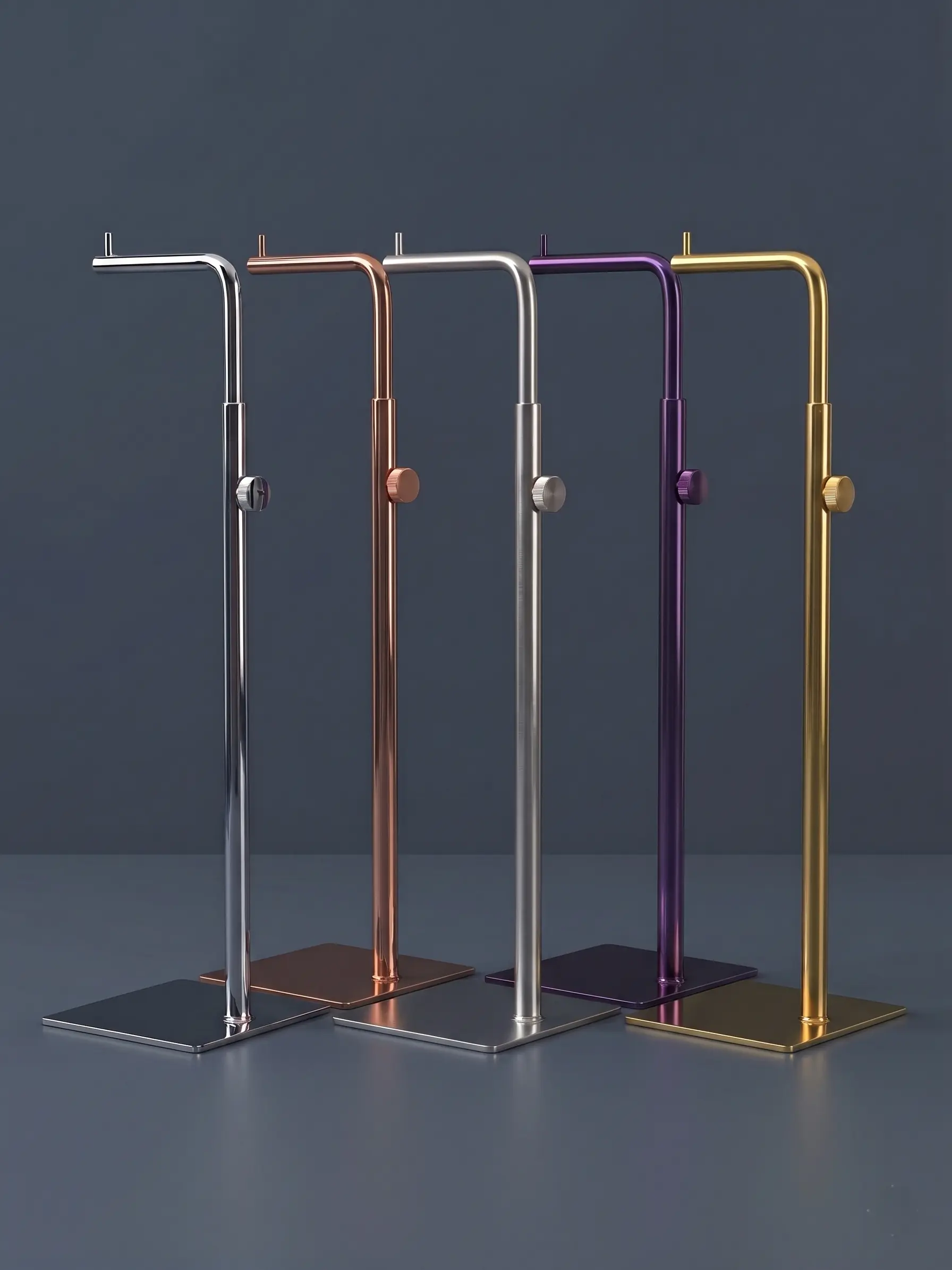 Row of thin metal supports for displays, with colored finishes (copper, gold, silver, purple) on a stainless steel base